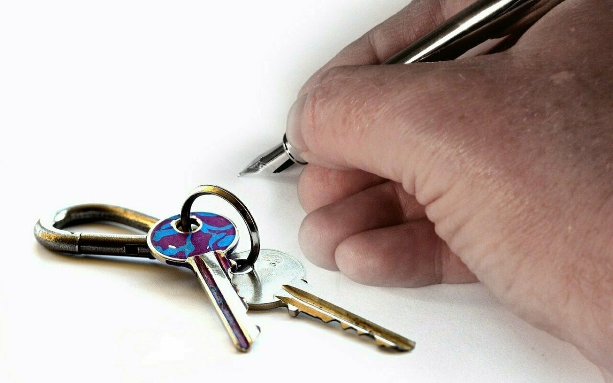 Ein Mietvertrag wird unterschrieben zu sehen ist eine Hand und ein Schluesselbund Ein Mietvertrag wird unterschrieben zu sehen ist eine Hand und ein Schluesselbund